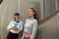 Two young sporty woman standing near wall and have a rest after morning running in city Royalty Free Stock Photo