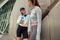 Two young sporty woman standing near wall and have a rest after morning running in city Royalty Free Stock Photo