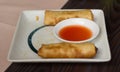 Two spring rolls on a greasy plate