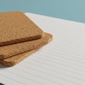 Two square cork coasters are stacked on a lined notebook. The notebook features Royalty Free Stock Photo