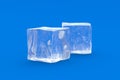Two square ice cubes on blue background. Cold beverages Royalty Free Stock Photo