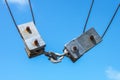 Two square metal blocks and pulleys from a commercial fishing boat fastened together - close-up - against a blue sky