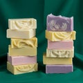 Two stacks of artisanal soap bars are displayed against a rich green fabric backdrop. Royalty Free Stock Photo