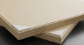 Two stacks of beige paper sheets are placed on a smooth surface. Each stack is Royalty Free Stock Photo