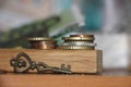 Two Stacks of coins and a key on a wooden background with reflection. Key to profit secret of money gain business concept