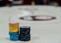 Two stacks of poker chips with defocused poker table in background Royalty Free Stock Photo