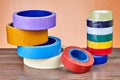 Two stacks of rolls of multi-colored adhesive tape.