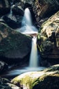 Two-stage waterfall on the river Jedlova in the Jizera Mountains, Czech Republic. Slow-motion. The rays irradiate the water to