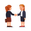 Two standing business woman shaking hands firmly