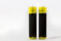 Two standing yellow-black AAA alkaline batteries isolated on white