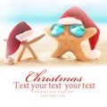 Two starfish on summer beach and santa hat. Royalty Free Stock Photo