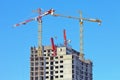 Two stationaty hoists over on a building of a skyscrape in front