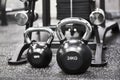 Two steel black kettlebells on gray floor in modern gym