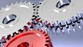 Two steel gears in connection with red one Royalty Free Stock Photo