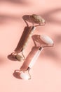 Two stone jade rollers on pink background