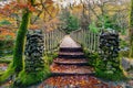 Two stone pillars of old wooden bridge with mossy rocks in Tollymore Forest Park Royalty Free Stock Photo