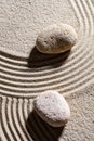 Two stones across sand lines for concept of spirituality Royalty Free Stock Photo
