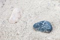 Two stones, light and dark, laying separately on the sand Royalty Free Stock Photo