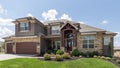 Two-storey beautiful expensive house with a garage surrounded by green manicured lawn and bushes