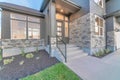 Two storey home facade with stone brick wall and glass paned gray front door