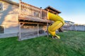 Two storey home with yellow slide on the deck going down to the spacious yard