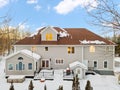 Two-storey white house surrounded by snow-covered trees and shrubs in New England Royalty Free Stock Photo