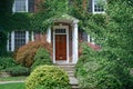 two story brick house, covered in vines and bushes Royalty Free Stock Photo