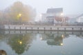 Two story house with American flag in mist foggy early morning along historic Erie Canal with yellow pole lighting, colorful fall Royalty Free Stock Photo