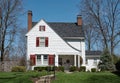 White Shake House with Peaked Roof & Red Shutters