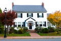 two-story single-family house by the road. Lawn and trees in autumn colors Royalty Free Stock Photo