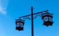 two street lamps with clock faces lit up against the blue sky Royalty Free Stock Photo