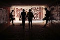 Two street musicians playing guitar in the underpass. People pass by. Silhouette photo. Vagrant lifestyle. Playing to make money a