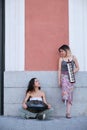 Two street musicians looking each other and smiling, playing instruments. Royalty Free Stock Photo