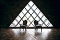 Two striped chairs, black and white, against a background of a triangular window, empty loft, stylish look