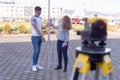 Two students of architecture doing practice lessons as Surveyor Engineering. SurveyorÃ¢â¬â¢s telescope at construction site for