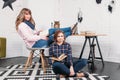 Two students doing homework together and helping each other sitting in a table at home with a homey background