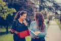 Two students learning reading a notebook and commenting in the street Royalty Free Stock Photo