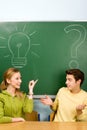 Two students with light bulb and question mark Royalty Free Stock Photo