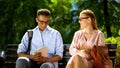 Two students making acquaintance sitting on bench in park, first impressions