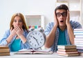 Two students runnng out of time to prepare for exams Royalty Free Stock Photo