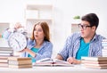 Two students runnng out of time to prepare for exams Royalty Free Stock Photo