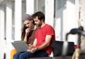 Two students sitting at campus looking at laptop together Royalty Free Stock Photo