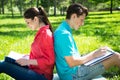 Two students studying in park on grass Royalty Free Stock Photo