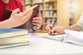 Two students studying, reading and writing in library. Royalty Free Stock Photo