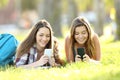 Two students texting in their smart phones in a park