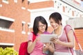 Two students using a tablet to discuss homework