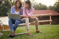 Two students wrting a paper together outiside