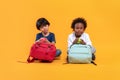 Two students 3 years, Asian and Black child boy of different nationalities with school bag to sit quietly look camera, Isolated