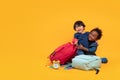 Two students 3 years, Asian and Black child boy of different nationalities with school bag to sitting enjoy in a hug and playing