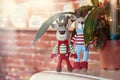 Children toys. Two stylish amigurumi deers in striped sweaters, scarf and butterfly tie standing near flowerpot Royalty Free Stock Photo